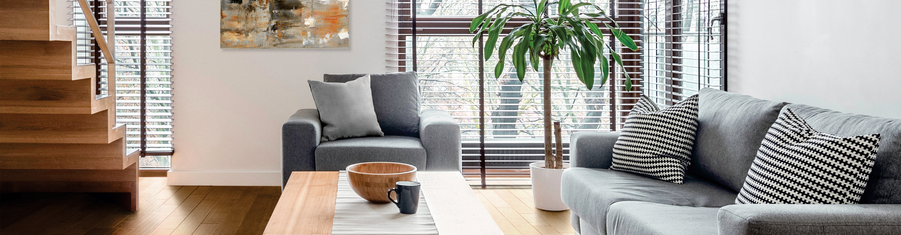 living room with wood floors, grey furniture and blinds