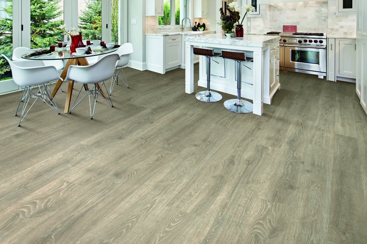 Laminate flooring in a kitchen and dining room with white cabinetry