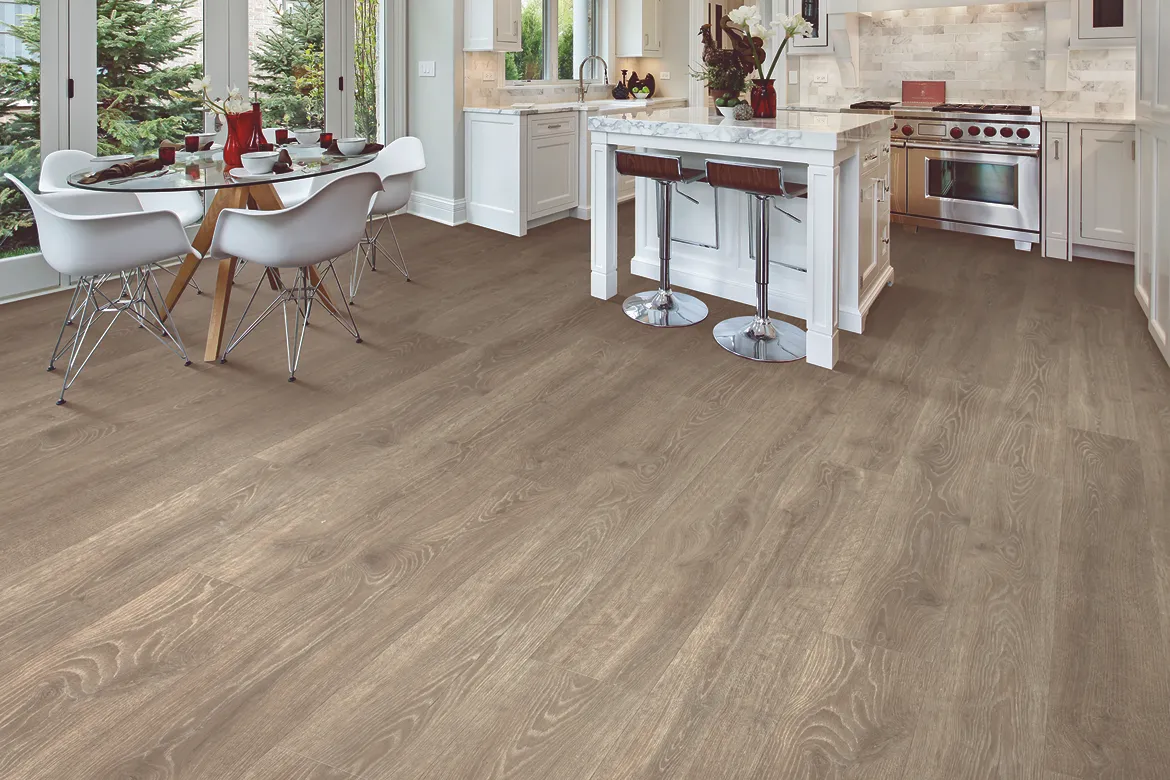 Laminate flooring in a kitchen and dining room with white cabinetry